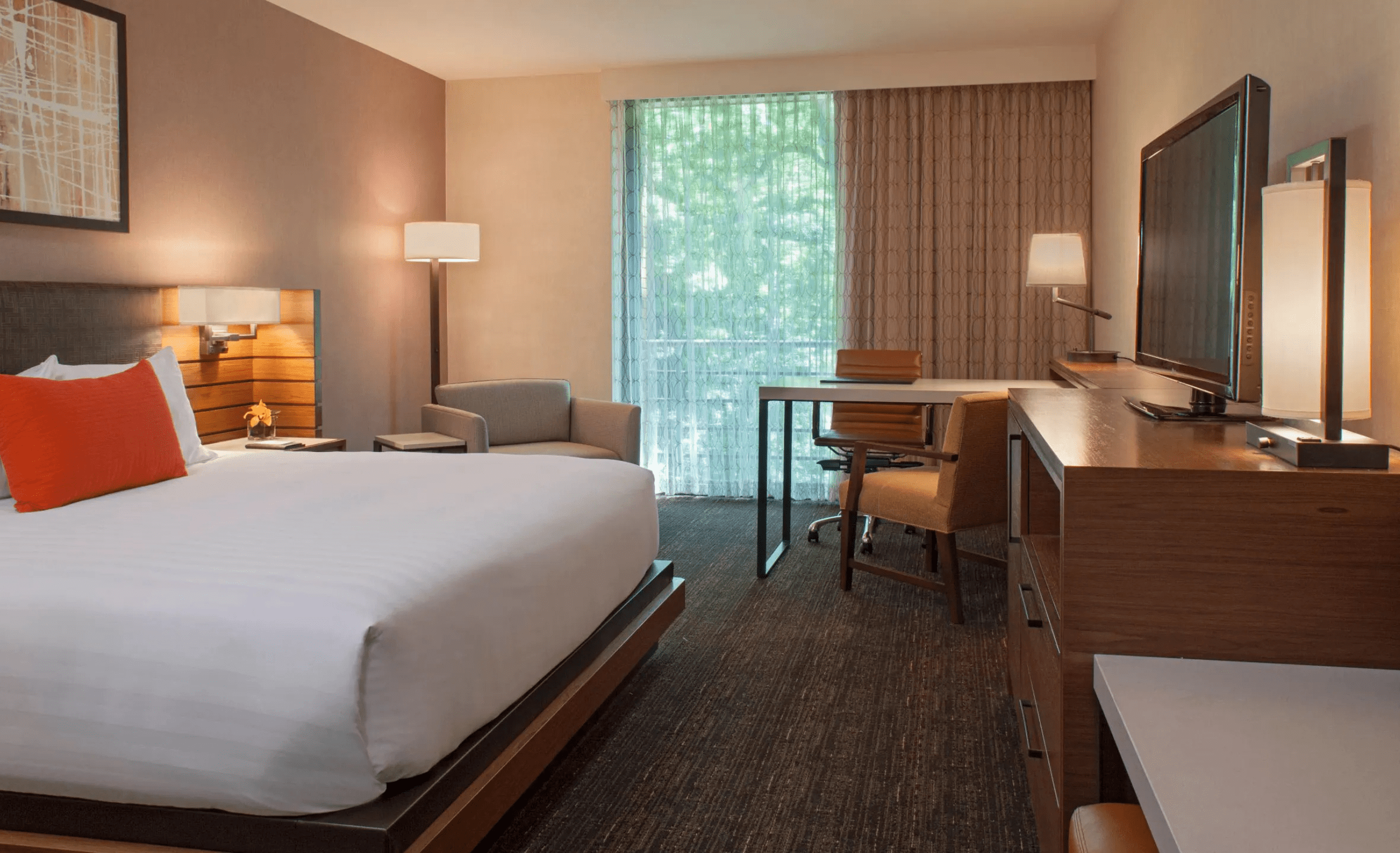 Hotel room with white bed and orange pillow